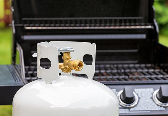 Bouteille de propane posée devant le barbecue.