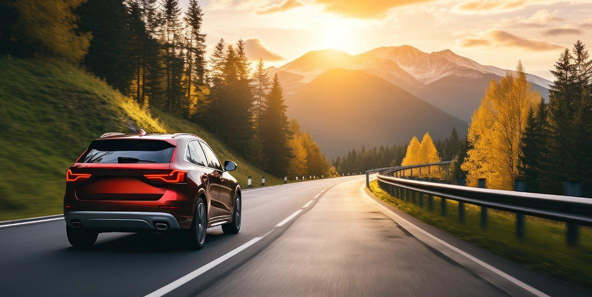 Voiture conduisant au coucher du soleil sur la montagne.